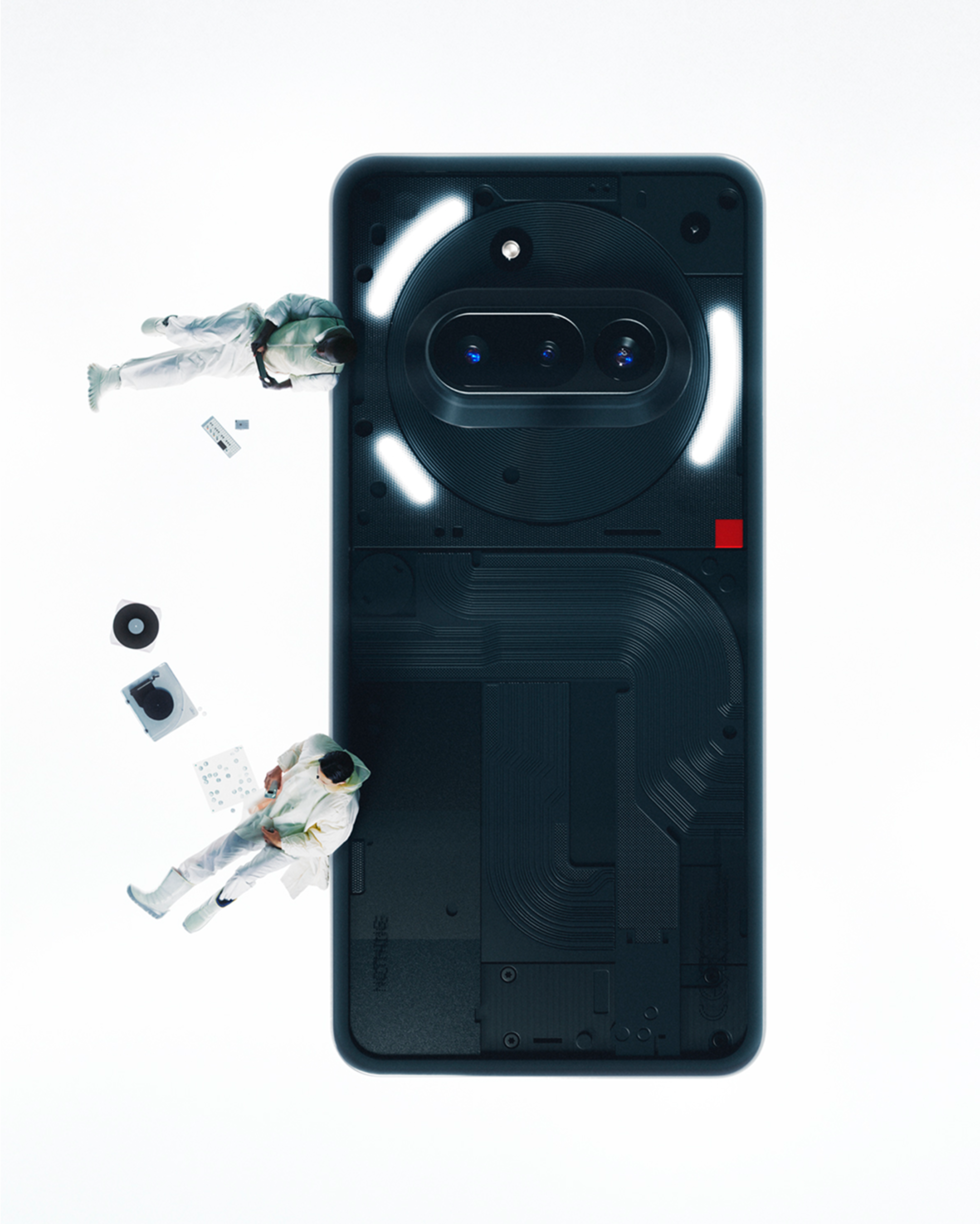 Ein Smartphone mit einzigartigem Rückendesign, mit zwei kleinen Astronauten und einigen Gegenständen drumherum.